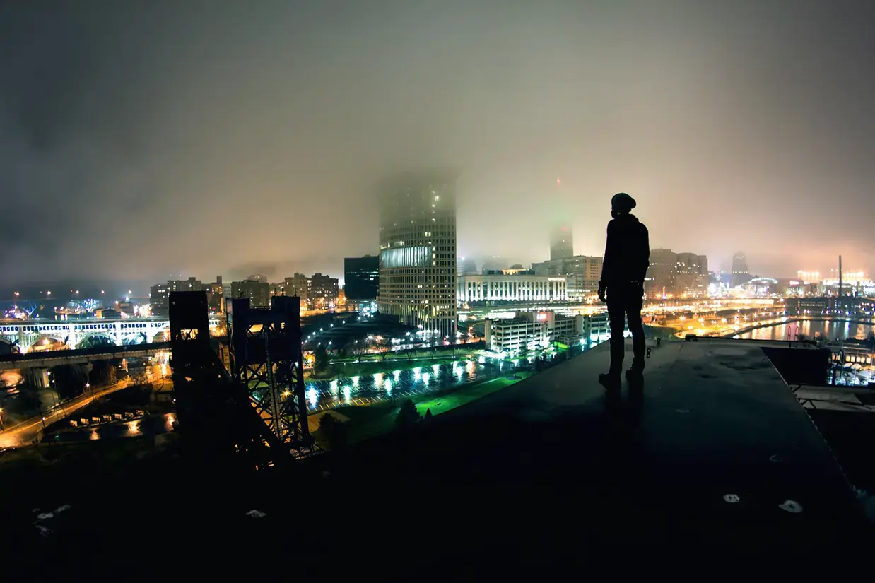 A self portrait standing on top of an abandoned lift bridge with the Cleveland skyline behind me